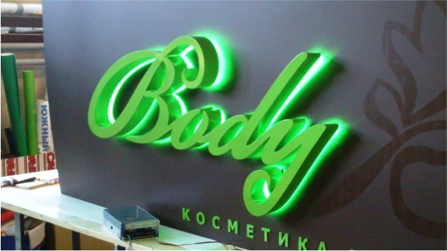 Зелёная светящаяся вывеска с фигурными буквами